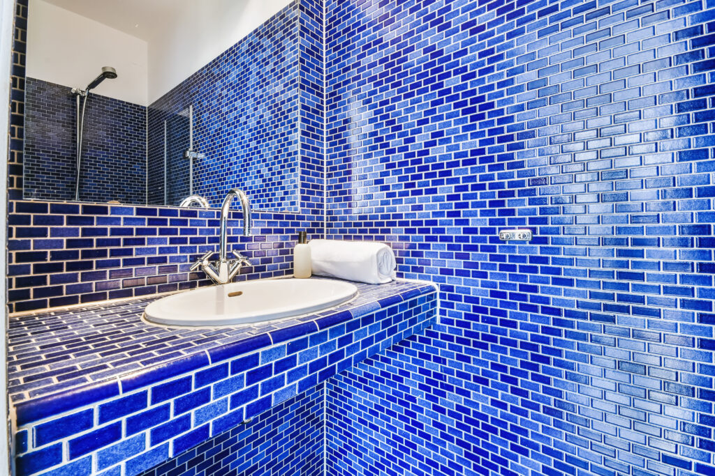 A beautifully tiled bathroom with various shades of blue tiles.